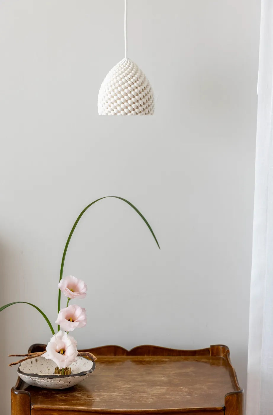 Porcelain Sahara pendant above a flower arrangement