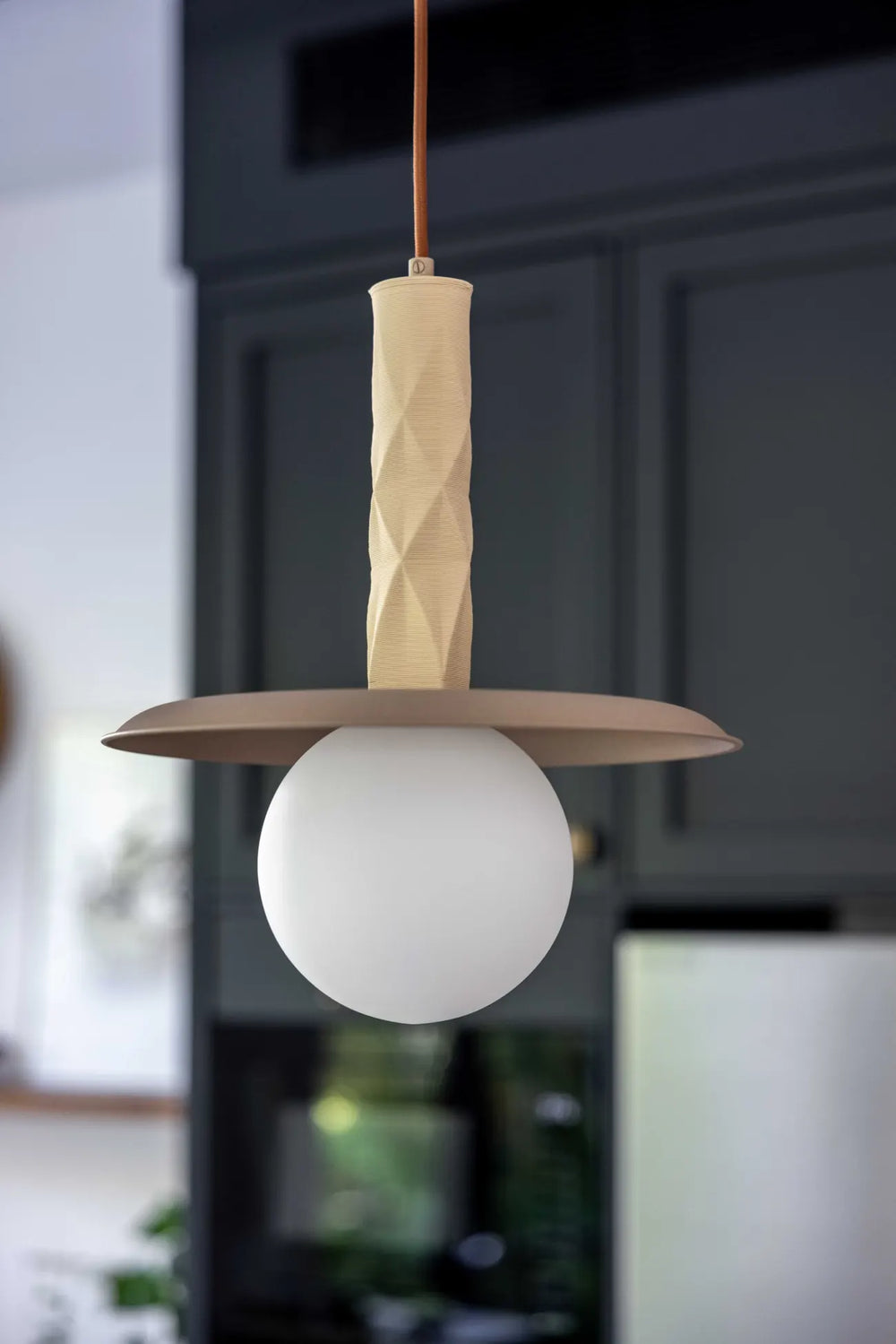 Sono pendant with a milky glass globe over a dark kitchen